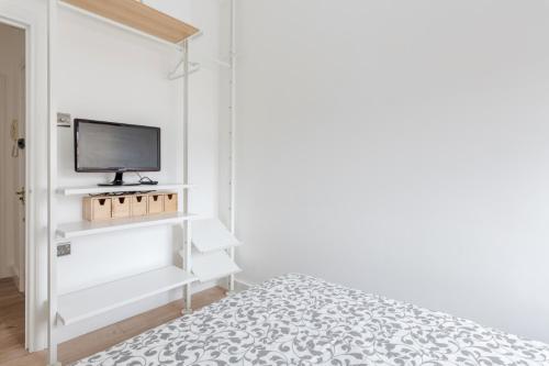 a bedroom with a bed and a tv on a shelf at Live like a Londoner by TOWER BRIDGE in London