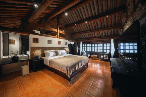een slaapkamer met een bed in een kamer met houten plafonds bij Dongsheng Design Hotel in Dali in Dali