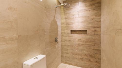 a bathroom with a shower with a toilet at RedDoorz at Anton's Loft Designer Resort Pansol Calamba Laguna in Laguna