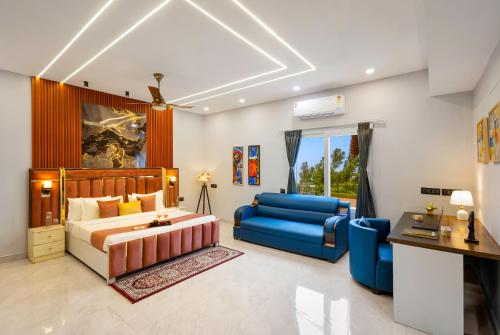 a bedroom with a bed and a blue couch at Aurea 4-BHK Farmhouse With Private Pool, Garden & Gazebo in Greater Noida