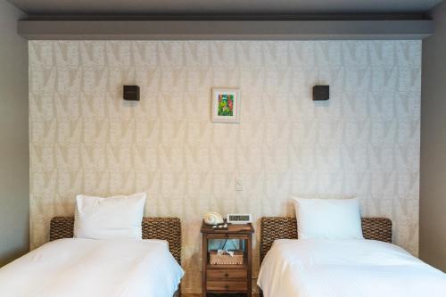 Dos camas una al lado de la otra en una habitación. en Alezed Villa Shiraho, en Ishigaki Island