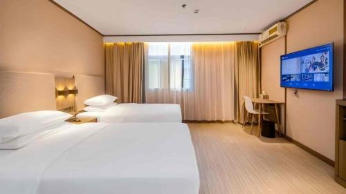 Ένα ή περισσότερα κρεβάτια σε δωμάτιο στο Hanting Hotel Shenzhen Huaqiang North Science Museum Subway Station