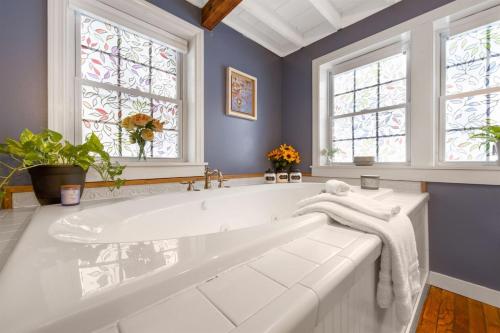 eine weiße Badewanne in einem Badezimmer mit Fenster in der Unterkunft Lake Front-Spa Tub-Fire Pit-Full Kitchen-Canoe in Bucksport