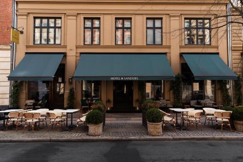 a restaurant with tables and chairs in front of a building at Hotel Sanders in Copenhagen