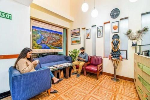 dos personas sentadas en una sala de espera en FabHotel F9 NFC, en Nueva Delhi