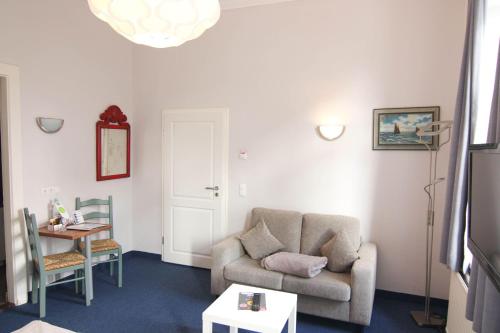 Kapitaenshaus-Lassen-Zimmer-Amistad في فيسترلاند: غرفة معيشة بها أريكة وطاولة