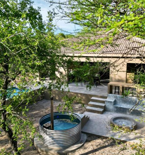 a garden with a hot tub and a building at Dung Beetle Bush Villa in Marloth Park