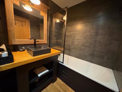 un bagno con lavandino e vasca da bagno di Appartement de Standing - ARC 1950 - 6 personnes - départ et retour à skis ad Arc 1950