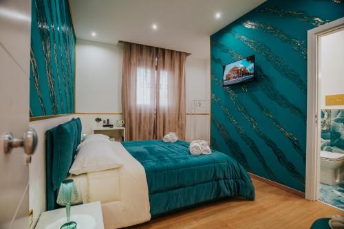a bedroom with a bed with a green wall at Cama Luxury Rooms in Palermo