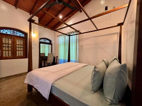 a bedroom with a large bed with white sheets and pillows at Laguna Beach Garden in Uswetakeiyawa
