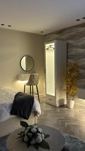 een slaapkamer met een bed, een spiegel en een tafel bij Elegant studio in Riyad