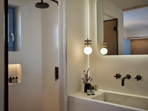 um banheiro com uma pia e um espelho em Liostasi Ona Villa em Ios Chora