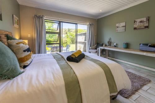 Un dormitorio con una cama grande con una ventana grande. en En-suite, private room, free WIFI in Plett, en Plettenberg Bay