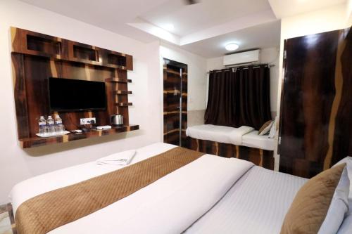 Best Buy Hotel في كولْكاتا: غرفة فندق مع سرير وتلفزيون