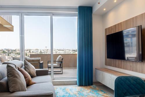 a living room with a couch and a tv at Offshore Suites Apartments in St Julians Centre in St. Julianʼs