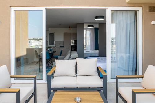 a living room with two chairs and a couch at Offshore Suites Apartments in St Julians Centre in St. Julianʼs