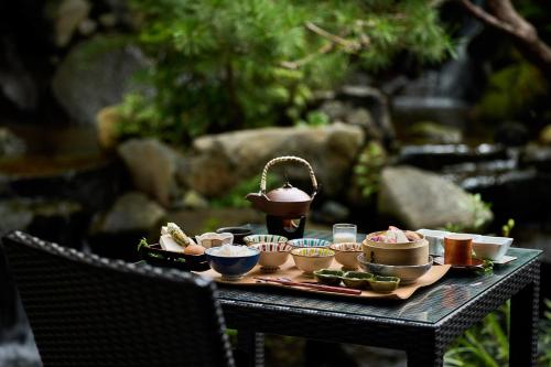 a table topped with bowls and plates of food at Bessho Onsen Midoriya in Ueda