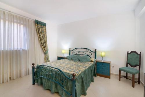 una camera da letto con un letto, una sedia e una finestra di Casa da Várzea a Roja- Pé