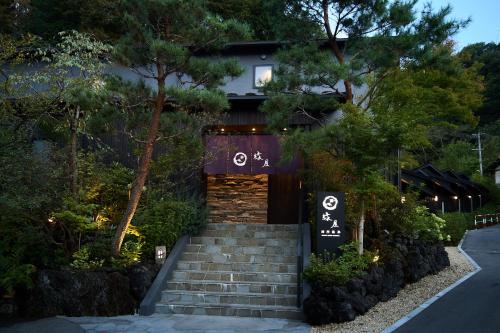 a building with a staircase in front of a house at Bessho Onsen Midoriya in Ueda