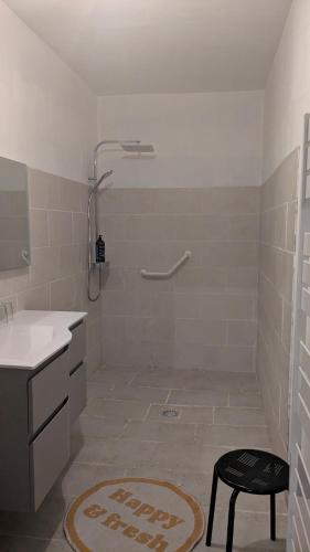 a bathroom with a shower and a stool in it at La gargolette in Chevenon