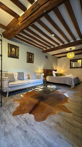 a living room with a couch and a table at Les Maisons d'Augustine, demeure de charme de la cour Ste Catherine in Honfleur