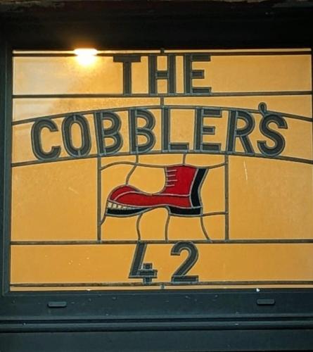 a sign for a coffee shop with a red shoe at Welcome to the Cobbler's at Barry Island in Barry
