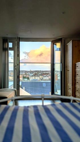 a bedroom with a bed and a view of the water at Welcome to the Cobbler's at Barry Island in Barry