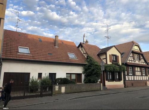 un uomo che cammina lungo una strada davanti alle case di Maison MidCentury chaleureuse proche centre-ville a Strasburgo