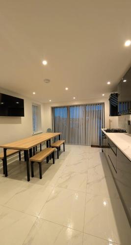 a kitchen with wooden tables and benches in a room at Welcome to the Cobbler's at Barry Island in Barry