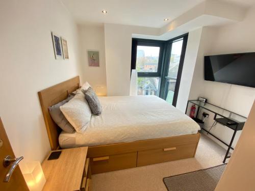 a bedroom with a bed with a desk and a television at Sheffield City Centre Apartment & Balcony in Sheffield
