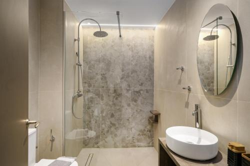 Un baño con ducha con lavabo y espejo. en Axos, en Platanes