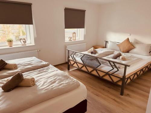 two beds in a room with two windows at Ferienwohnung Hotel Preyt in Holtland