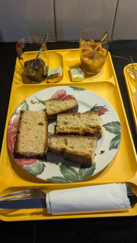 Ein Teller mit vier Brotscheiben auf einem gelben Tablett in der Unterkunft La gargolette 