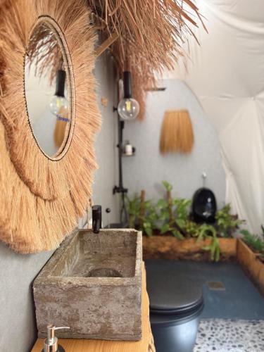 a bathroom with a stone sink and a mirror at Seed Domo Tarifa in Betis