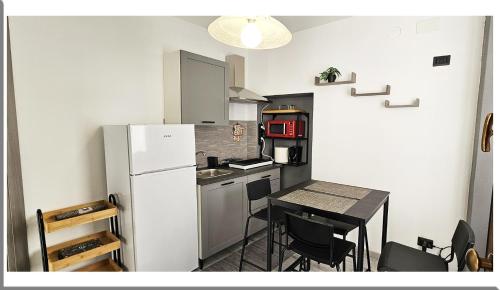 Romantic Retreat On The Lake في Nebbiuno: مطبخ مع ثلاجة وطاولة مع كراسي