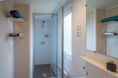 a bathroom with a shower with a glass door at Camping Les Fontaines in Ivry-la-Bataille