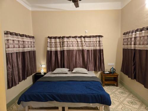 une chambre avec un lit et deux fenêtres dans l'établissement Indrapuri Home Stay, à Bolpur