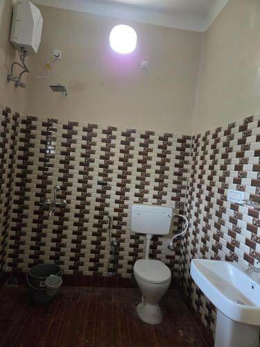 une salle de bains avec toilettes et lavabo dans l'établissement Indrapuri Home Stay, à Bolpur