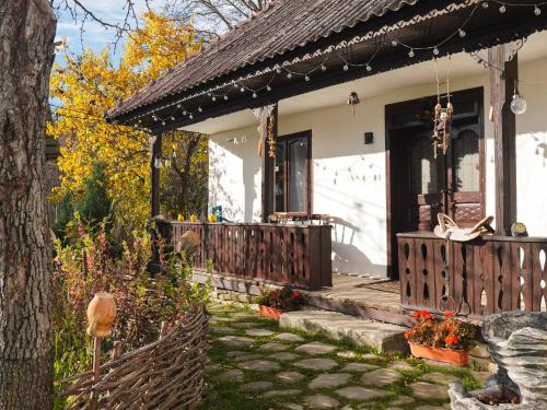 a white house with a wooden gate and a porch at Pensiunea Cocoș in Spulber
