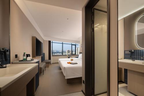 a hotel room with a bed and a bathroom at Xi Gu Hotel Wuhan Xudong Metro Station Branch in Wuhan