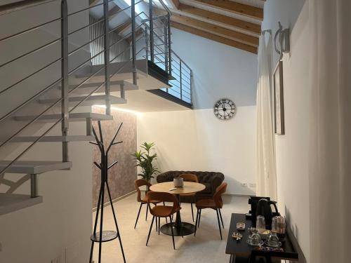 Una sala de estar con una mesa y una escalera de caracol. en GV Guest House Malpensa, en Lonate Pozzolo