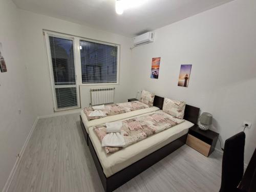 a bedroom with two beds and two windows at UniMuni in Ruse