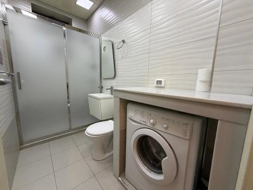 Un baño con lavadora y un inodoro. en Passage apart, en Baku