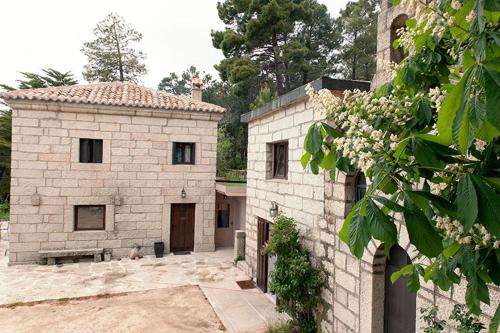 a stone building and a building with a yard at Huerto San Antonio in La Cabrera