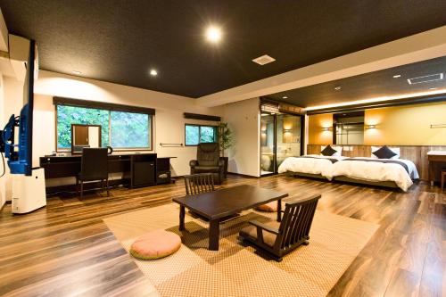 a bedroom with a bed and a desk and a bed and a table at LiVEMAX RESORT Hakone Sengokuhara in Hakone