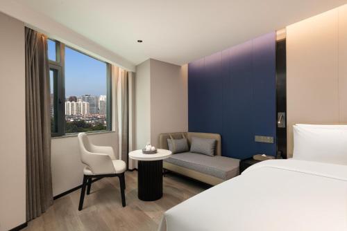 a hotel room with a bed and a couch and a table at FeNo AESTHETIC DESIGNER Hotel Beijing Road Pedestrian Street Branch in Guangzhou