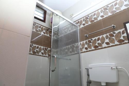 蓬蒂切里MP Villa的带玻璃淋浴和马桶的浴室