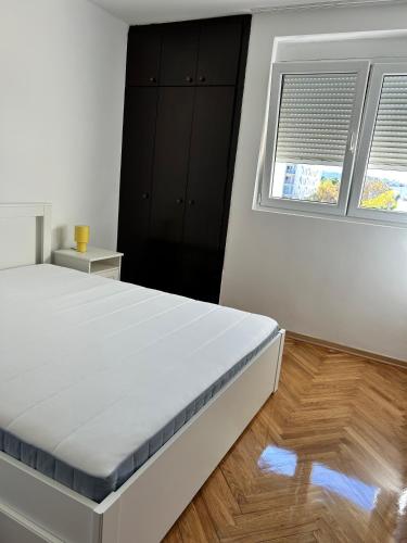 a white bedroom with a bed and a window at Stay In Bar in Bar