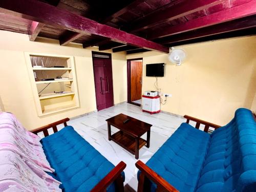 Una sala de estar con dos sillas azules y una mesa. en Edwin and Edrin Service Villa, en Wayanad
