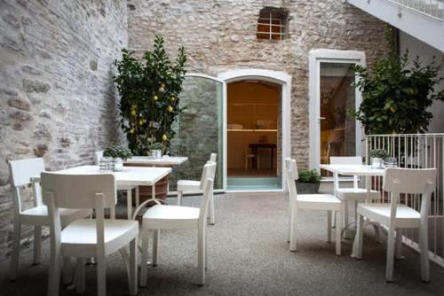 圣阿尔坎杰洛-迪罗马涅Le Contrade - Dimora nel Borgo的一间设有白色桌子和白色椅子的餐厅